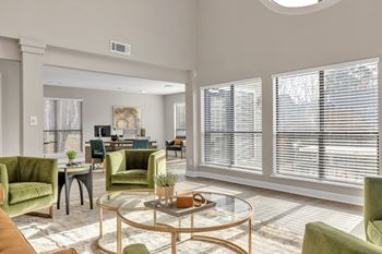 A living room with large windows and a glass coffee table